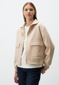Beige cropped jack met een gladde stof, met een knoopsluiting aan de voorkant, twee voorzakken en geribde manchetten en zoom.