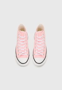 Pink high-top sneakers with canvas upper, white laces, black rubber sole, and toe cap. Features silver eyelets and contrasting stitching.