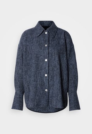 Mornariće plava tkanina, košulja s oštrim ovratnikom, zatvaranjem na dugmad, dugim rukavima i zaobljenim rubom. Teksturirana tkanina s suptilnim uzorkom.