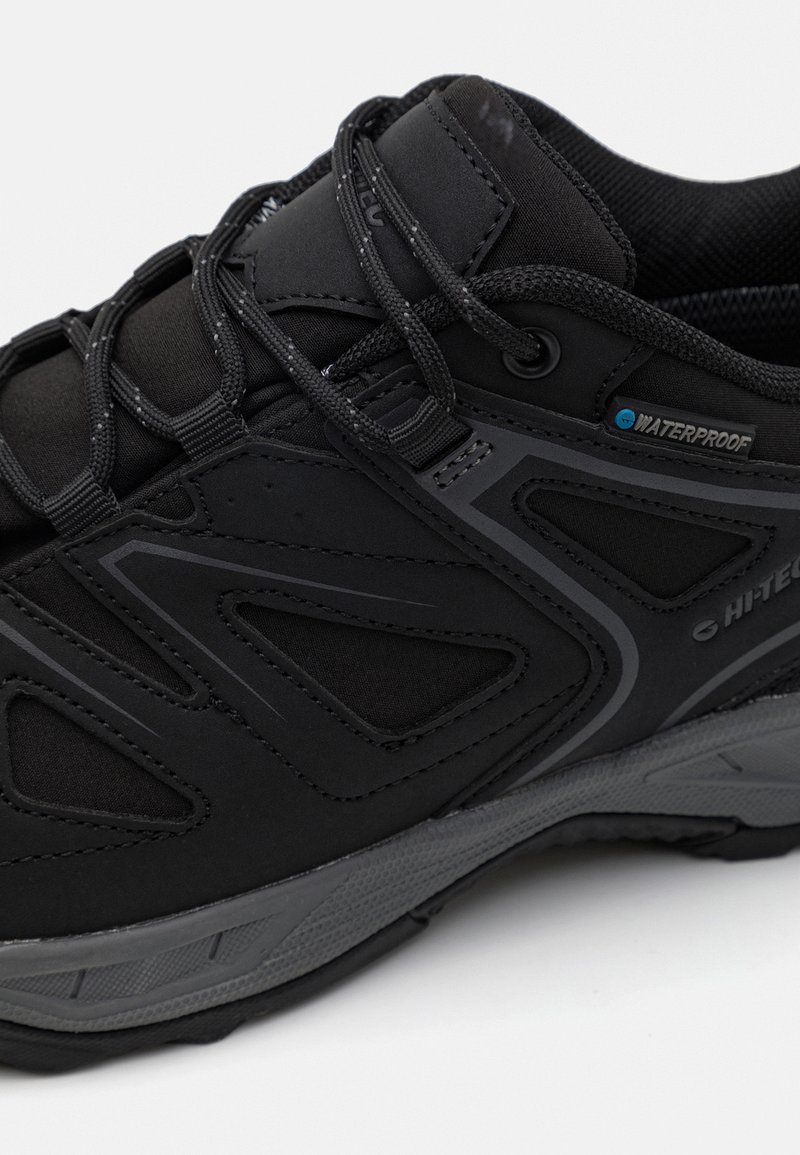 Schwarzer wasserdichter Wanderschuh mit strukturiertem Stoff, Netzakzenten und reflektierenden Details. Verfügt über eine gepolsterte Sohle und ein unterstützendes Design.