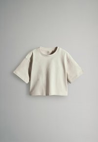 Helles beige, croppedes T-Shirt aus weicher Baumwolle, mit rundem Halsausschnitt und kurzen Ärmeln in lässiger Passform.