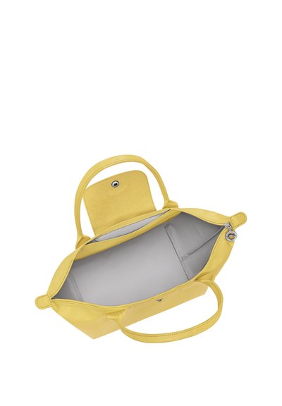 Yellow leather handbag with two handles, open top zipper, and interior pouch pocket, shown empty against white background.