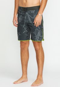 Pantaloni da bagno neri con motivo floreale grigio chiaro e bordo verde. Dotati di una vita elastica con cordoncino per una vestibilità regolabile.