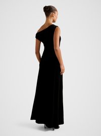 Black velvet dress with an asymmetrical shoulder design, featuring a draped effect and a floor-length silhouette. Smooth texture and fitted shape.