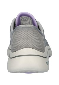Grijze textiel en synthetische sneaker met een gewatteerde paarse kraag, een gestructureerde bovenkant en een witte tussenzool. Beschikt over een subtiel logo op de zijkant.
