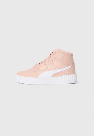 Baskets montantes roses avec une bande blanche Puma, semelle épaisse blanche, lacets et doublure en polaire sur un fond clair uniforme.