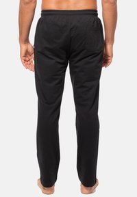 Zwarte katoen broek met een elastische tailleband, achterzak en een recht gesneden ontwerp. Zachte textuur en minimalistische stijl zonder patronen.