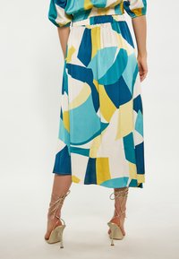 Fustă midi cu un model abstract multicolor în nuanțe de albastru, galben și alb, realizată dintr-un material fin și ușor, cu talie elastică.