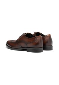 Braune Leder-Brogue-Schuhe mit dekorativen Perforationen. Abgerundete Zehen, Schnürdesign und schwarze Gummisohlen. Polierte Oberfläche.