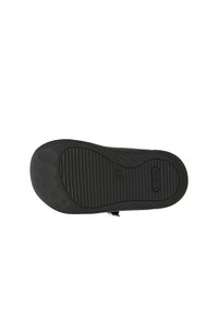 Semelle de chaussure en caoutchouc noir avec des rainures texturées et des motifs circulaires. Marque "BARTEK" visible près de la zone du talon.