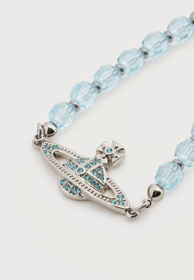 Ασημένι ο μενταγιόν σε σχήμα πλανήτη με μπλε κρυστάλλους σε βραχιόλι από ανοιχτό μπλε φασματικά χάντρες συνδεδεμένες με μεταλλικούς κρίκους.