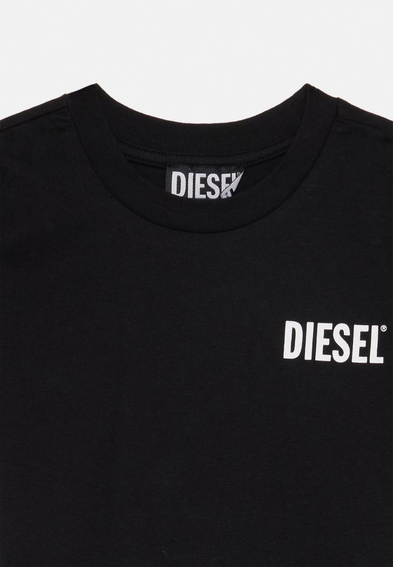 T-shirt in cotone nero con collo a giro, caratterizzato da un logo bianco "DIESEL" nella parte superiore sinistra del petto. Tessuto morbido, vestibilità standard.