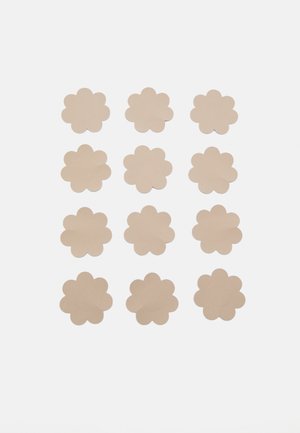Flower-shaped paper cutouts in a light beige color, arranged in a 4x4 grid. Each cutout features rounded petals and a smooth texture.