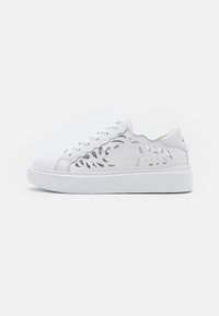 Białe sneakersy z solidną gumową podeszwą, z wyrafinowanymi wzorami wytłaczanymi po bokach oraz gładką skórzaną cholewką.