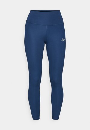 Navy blue athletic leggings made of stretchy fabric, featuring a high waist, smooth texture, and a small reflective logo on the side.