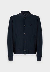 Φούτερ μπουφάν σε σκούρο μπλε ναυτικό χρώμα με κουμπιά μπροστά, ριμπ μανσέτες και τελείωμα, πλαϊνές τσέπες και μικρό λογότυπο στο στήθος. Λείο ύφασμα.