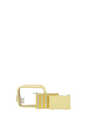 Tre borsette da bagno gialle: una trasparente con cerniera, una piccola a righe, una tinta unita, disposte fianco a fianco su sfondo bianco.