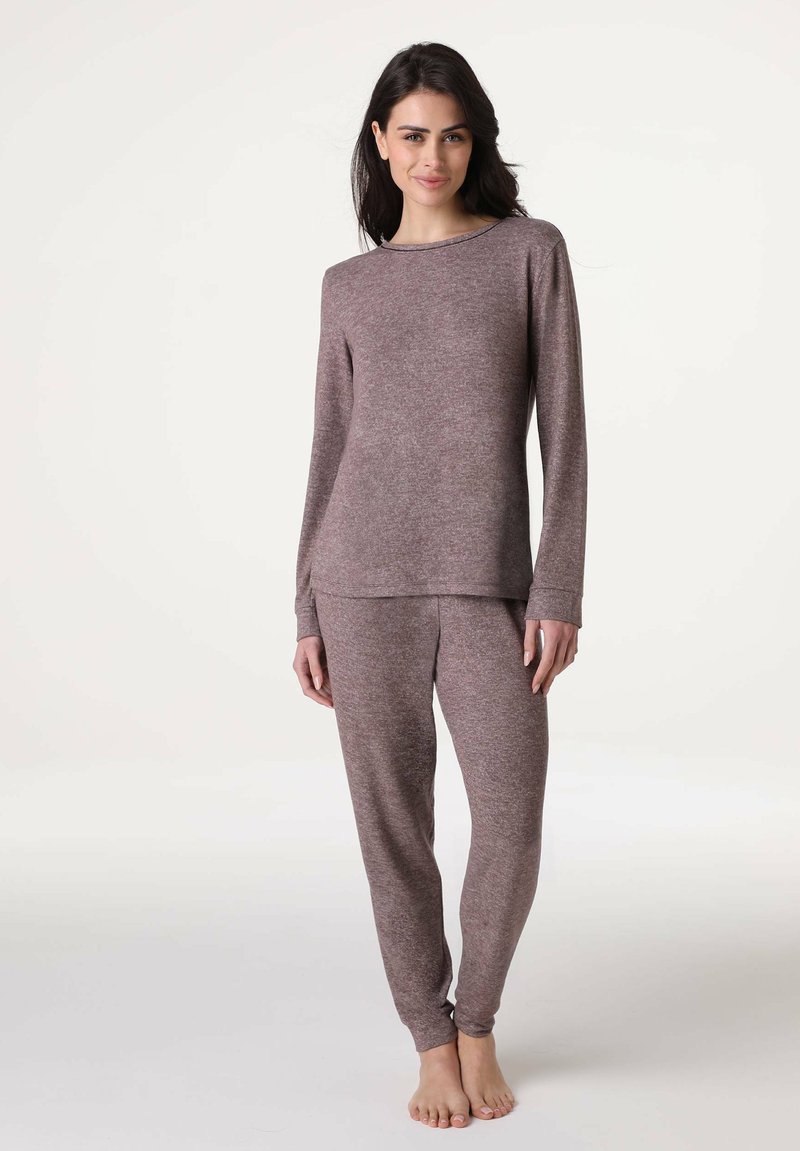 Top lungo a maniche con texture marrone e pantaloni abbinati. Il top presenta un colletto rotondo; i pantaloni hanno un fit affusolato alle caviglie.