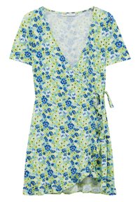 Vestido tipo wrap de manga corta con fondo verde y patrón floral en tonos azules, blancos y negros, atado en la cintura con un dobladillo con volantes.