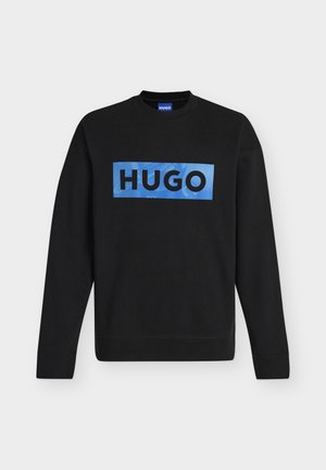 Schwarzes langärmeliges Sweatshirt mit Rundhalsausschnitt, blauem rechteckigem Aufnäher und fettem schwarzem "HUGO"-Schriftzug auf der Brust.