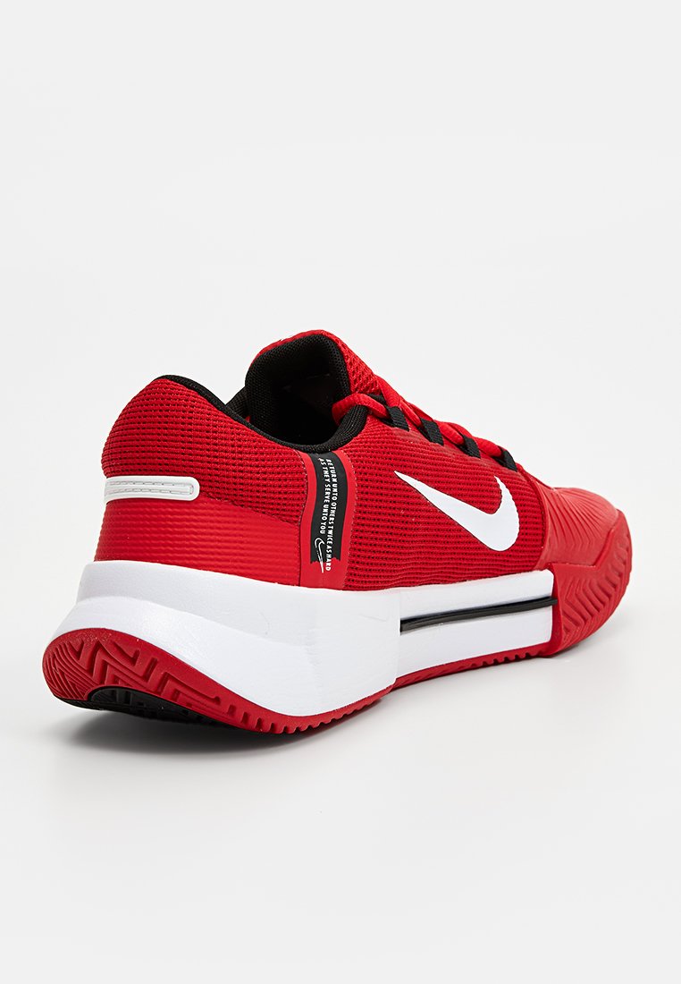 Roter Sportschuh mit einem strukturierten Mesh-Obermaterial, schwarzen Akzenten und dem weißen Nike-Logo. Verfügt über eine massive weiße Zwischensohle und eine gemusterte Laufsohle.