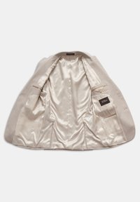 Beige blazer med satininteriör. Har två sidofickor, en bröstficka och en slät textur. Skräddarsydd passform med en enda luftventil.
