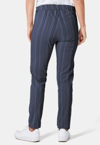 Marine gestreepte broek met een rekbare tailleband, slim fit en een gladde stofstructuur, gecombineerd met witte sportschoenen.