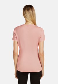 Kortärmad, rosa t-shirt tillverkad av lättviktsmaterial. Har rundad halsringning och en avslappnad passform. Slät textur utan synliga mönster.