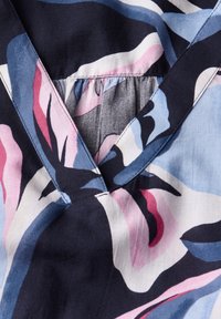Tessuto con motivo floreale caratterizzato da tonalità di blu, rosa e nero; design a V con dettagli arricciati sul collo; texture liscia.