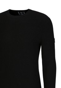 Schwarzer, gerippter Strickpullover mit rundem Halsausschnitt und langen Ärmeln. Verfügt über ein dezentes strukturiertes Muster und ein kleines Logo am Ärmel.