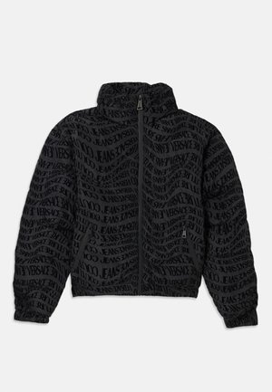 Black zipped jacket featuring a repeating text pattern of "Versace Jeans." Material has a textured appearance, with gathered sleeves and collar.