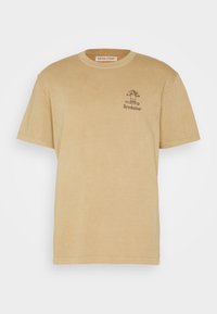 Beige cotton t-shirt with a crew neckline, short sleeves, and a small black graphic featuring a character and the word "Revolution" on the chest.
