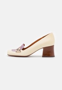 Chaussure femme beige à petit talon avec un talon en bloc marron et des accents décoratifs violets et à motif serpent sur le devant.