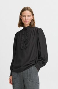 Schwarze Bluse mit langen Ärmeln, hohem Kragen und gerüschter Knopfleiste, ausgestattet mit Knopfverschlüssen und gerafften Schultern für zusätzlichen Textur.