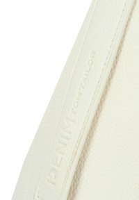 Bolso de mano de cuero blanco con superficie texturizada, que presenta un logotipo en relieve. La correa es lisa con costuras prominentes.