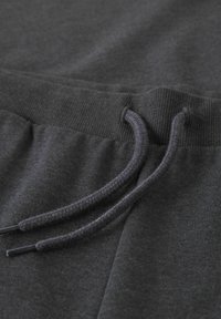 Mørkegrå joggingbukser med en glat tekstur, udstyret med ribbet taljebånd og snørre, samt to sidelommer.