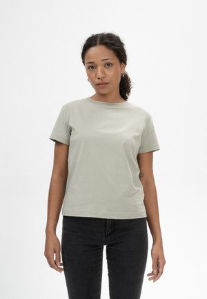 Lichtgroene, korte mouwen, katoenen t-shirt met een ronde halslijn, gecombineerd met zwarte spijkerbroek. Eenvoudig, ongecompliceerd ontwerp.