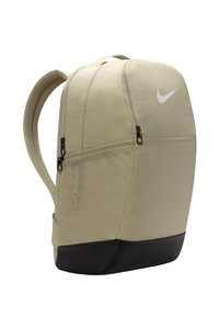 Mochila beige con un cuerpo texturizado, fondo negro, cremalleras suaves y un logo de swoosh blanco de Nike en el frente. Incluye correas ajustables de malla.