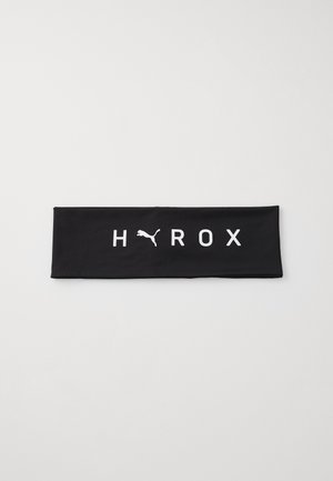 Banda de cap cu textura netedă, de culoare neagră, ce prezintă textul alb "HYROX" și un logo alb Puma. Formă rectangulară, design elastic.
