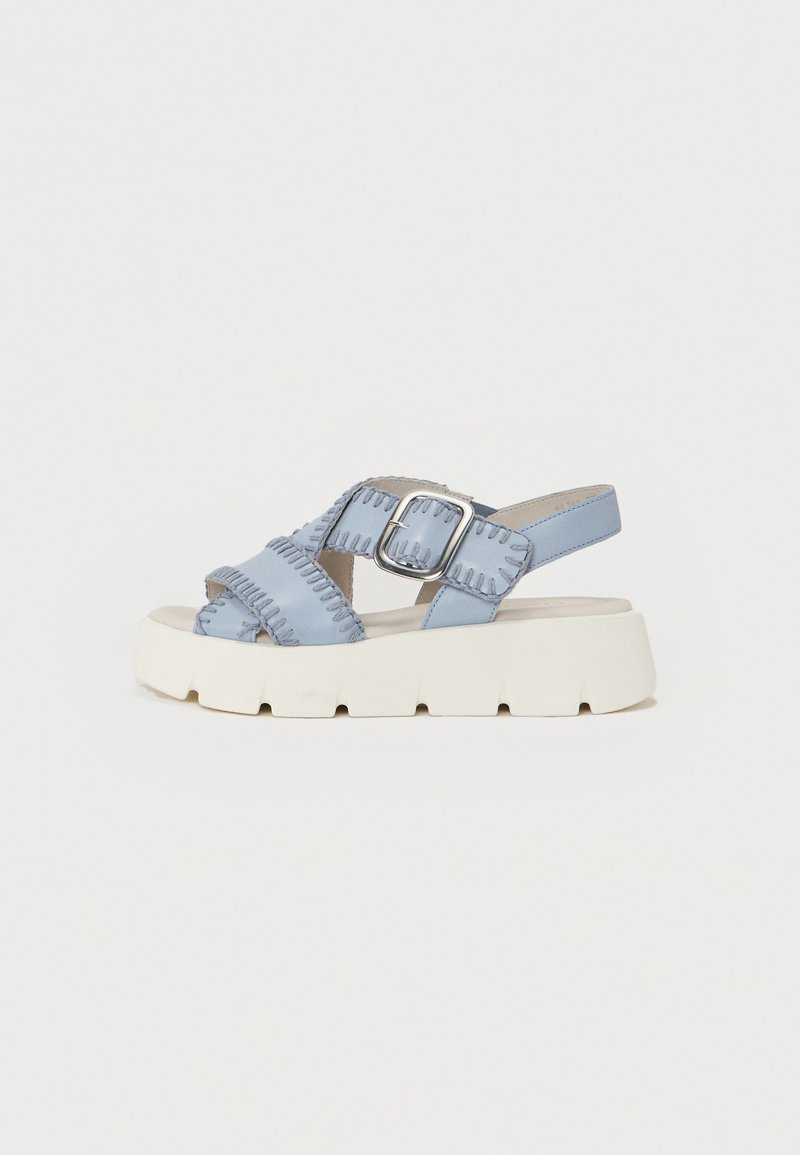 Lyseblå sandaler med en kraftig hvit såle, med en bred stropp med teksturdetaljer og en metallisk spenne aksent.