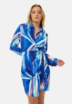Blue and white wrap dress with abstract brushstroke pattern, long sleeves, collar, and tie waist; lightweight fabric with smooth texture.