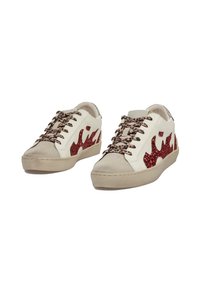Zapatillas blancas con diseño de llamas de purpurina roja, cordones de estampado de leopardo y punteras de ante beige.
