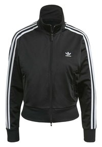 Svart zip-up-jacka av slät tyg, med hög krage, två framfickor och tre vita ränder på varje ärm. Adidas-logotyp på bröstet.