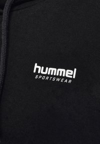 Svart hoodie i bomull, med en strukturerad tygkvalitet och en vit "hummel" logotyp med "SPORTSWEAR" under.