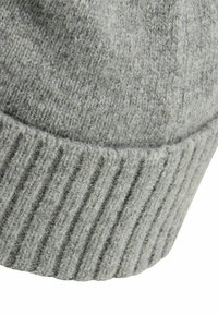 Grau gestrickte Mütze mit einem gerippten Bündchen und weicher Textur, mit leicht abgerundetem Oberteil. Das Material wirkt warm und gemütlich.