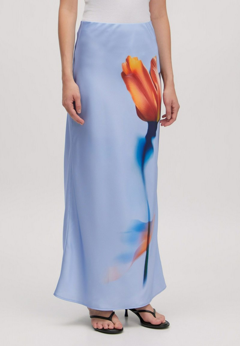 Lange blauwe rok van een gladde stof, met een bloemenprint in oranje en blauwtinten. Verfraaid met een vloeiende silhoutte en een zijsplit.