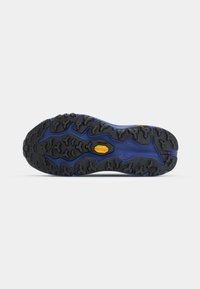 Black and blue athletic shoe sole featuring a rugged tread pattern, Vibram logo, and textured rubber for traction on various surfaces.