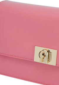 Borsa a mano in pelle rosa con finitura lucida, caratterizzata da una chiusura dorata e da una cucitura dettagliata lungo i bordi. Design compatto e strutturato.