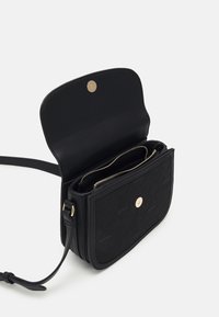 Borsa nera in pelle trapuntata con chiusura a scatto dorata, tracolla regolabile e due scomparti interni con zip per un'organizzazione ottimale.