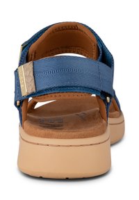 Blue fabric sandal featuring two adjustable straps, a cushioned brown insole, and a beige rubber sole with a textured finish. Gold-tone hardware detail.